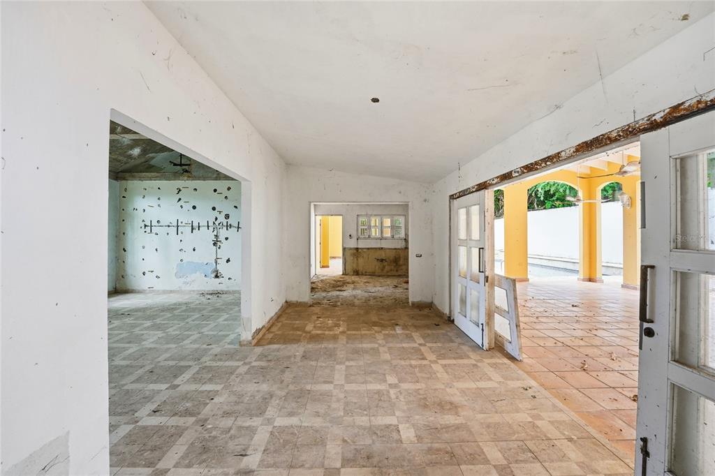 An interior view of a dilapidated room with tiled floors, white walls, and open doorways — 2 CALLE J, GUAYNABO, PR