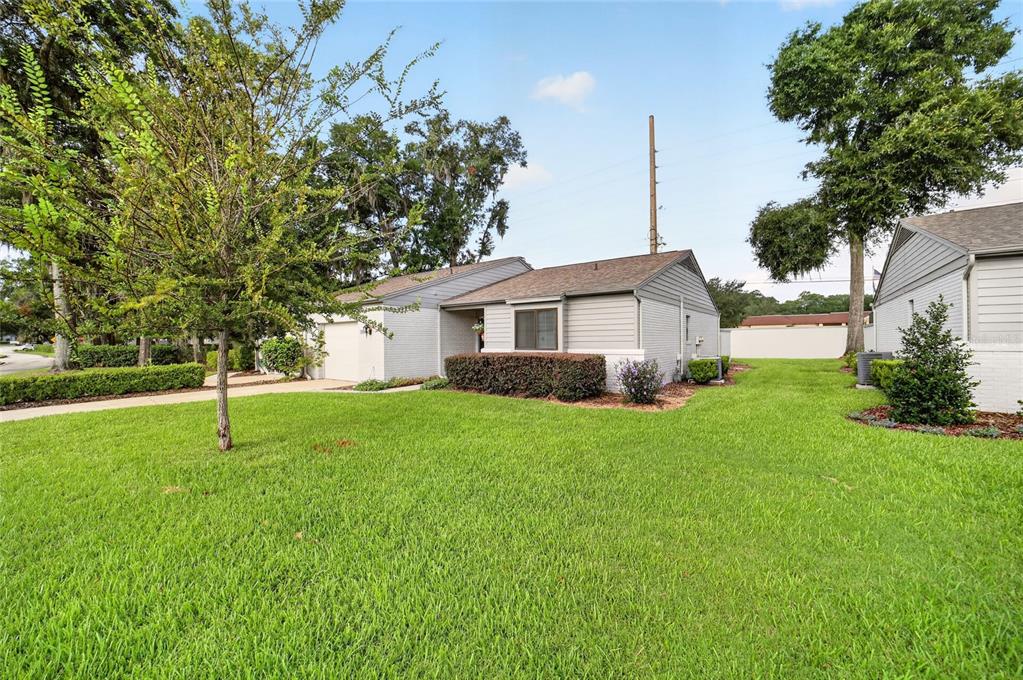 A single-story house with a gray exterior, a front lawn, and surrounding trees — 1904 SE 37TH COURT CIRCLE, OCALA, FL