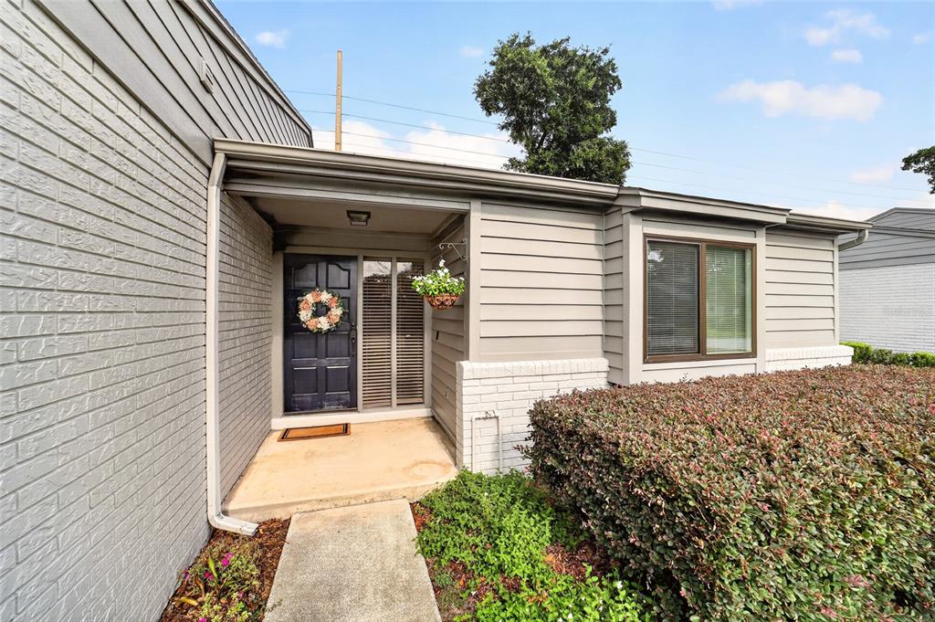 The exterior of a house features a gray brick wall, horizontal siding, and a front entrance — 1904 SE 37TH COURT CIRCLE, OCALA, FL