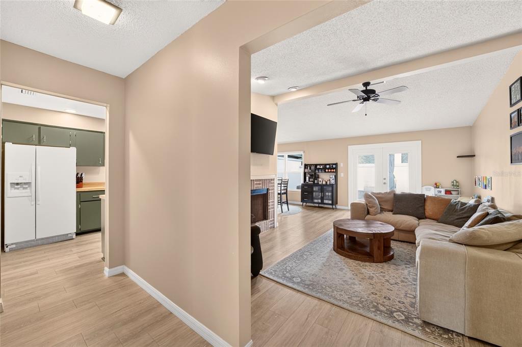 A view from a hallway looking into a living room with a sectional and kitchen — 1904 SE 37TH COURT CIRCLE, OCALA, FL
