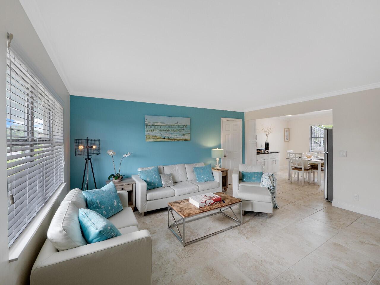 A living room with a blue accent wall, white furniture, and tile flooring — 1236 Beach Road # 2, Riviera Beach FL 33404, RIVIERA BEACH, FL