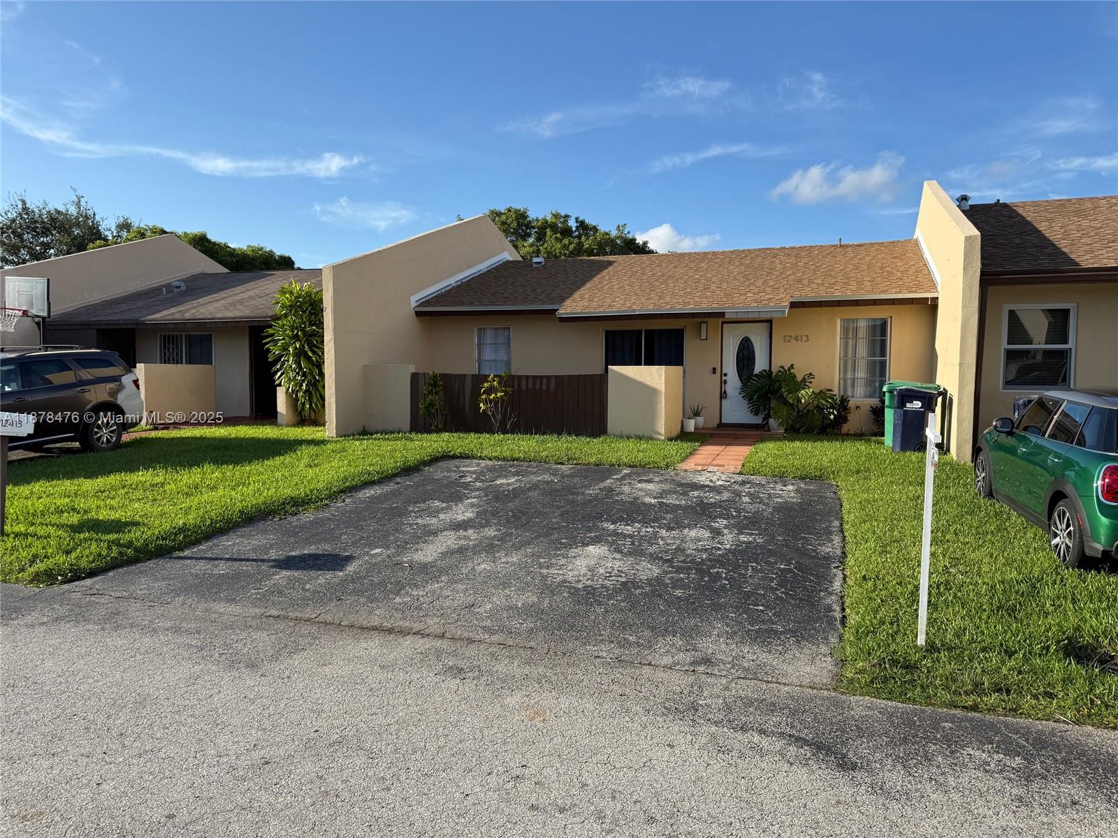 A single-story residential building with a tan exterior, shingled roof, and a paved driveway — 12413 SW 112th Ter, Miami FL 33186, MIAMI, FL