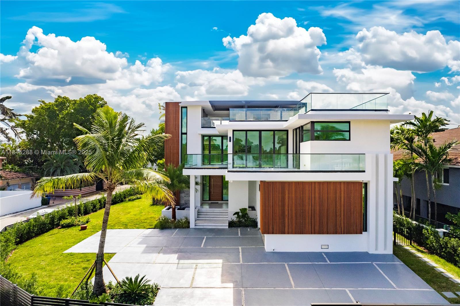 A modern three-story house features white walls, wood slat accents, glass balconies, and a paved driveway — 1248 NE 89th St, Miami FL 33138, MIAMI, FL