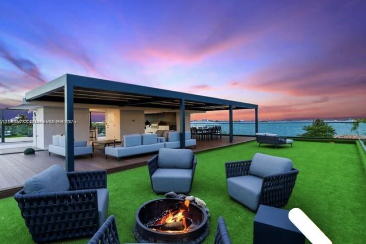 A rooftop terrace features a fire pit, lounge seating, and a covered patio overlooking the ocean — 1248 NE 89th St, Miami FL 33138, MIAMI, FL