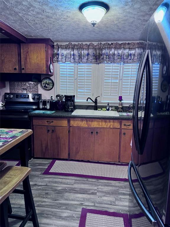 A kitchen features wood cabinets, a white farmhouse sink, and a window with shutters — 17134 LAKE INGRAM ROAD, WINTER GARDEN, FL