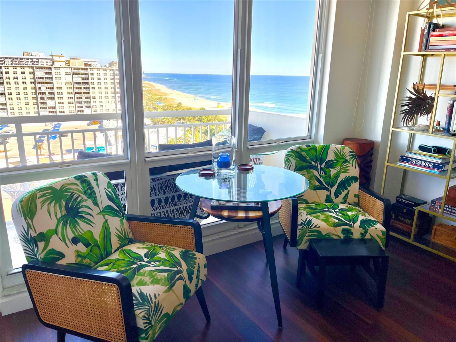 A seating area with two tropical-print chairs and a glass table overlooking the ocean — 133 N Pompano Beach Boulevard # 1506, Pompano Beach FL 33062, POMPANO BEACH, FL