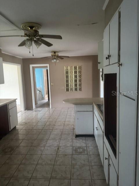 A kitchen with white cabinets, tile flooring, and two ceiling fans — 1921 GLENWOOD ROAD, DELAND, FL