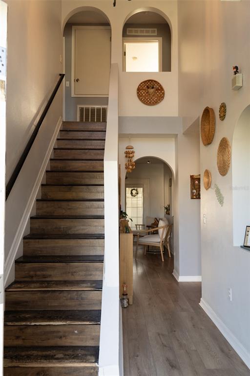 A staircase with dark wood treads leads to an upper landing beside a hallway entrance — 186 CEDAR RIDGE LANE, SANFORD, FL