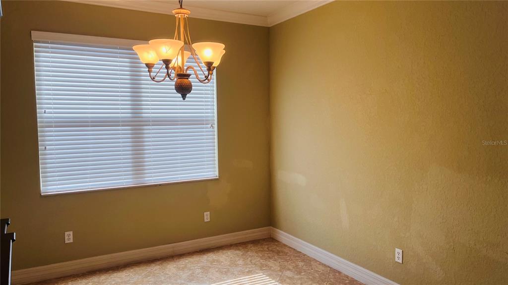 A dining room with a chandelier, a window with blinds, and tiled flooring — 1221 DUMAINE AVENUE, PORT ORANGE, FL