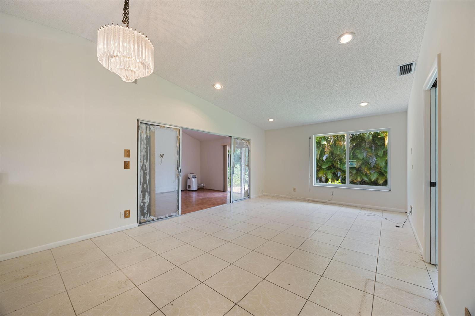 A brick patio leads to a front door with a black security screen — 5227 Copperleaf Circle, Delray Beach FL 33484, DELRAY BEACH, FL