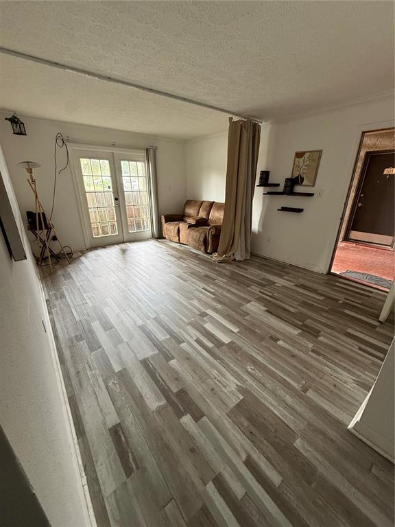 A living room features wood-look flooring, a brown sofa, a curtain divider, and glass doors — 305 WYMORE ROAD UNIT 100, ALTAMONTE SPRINGS, FL