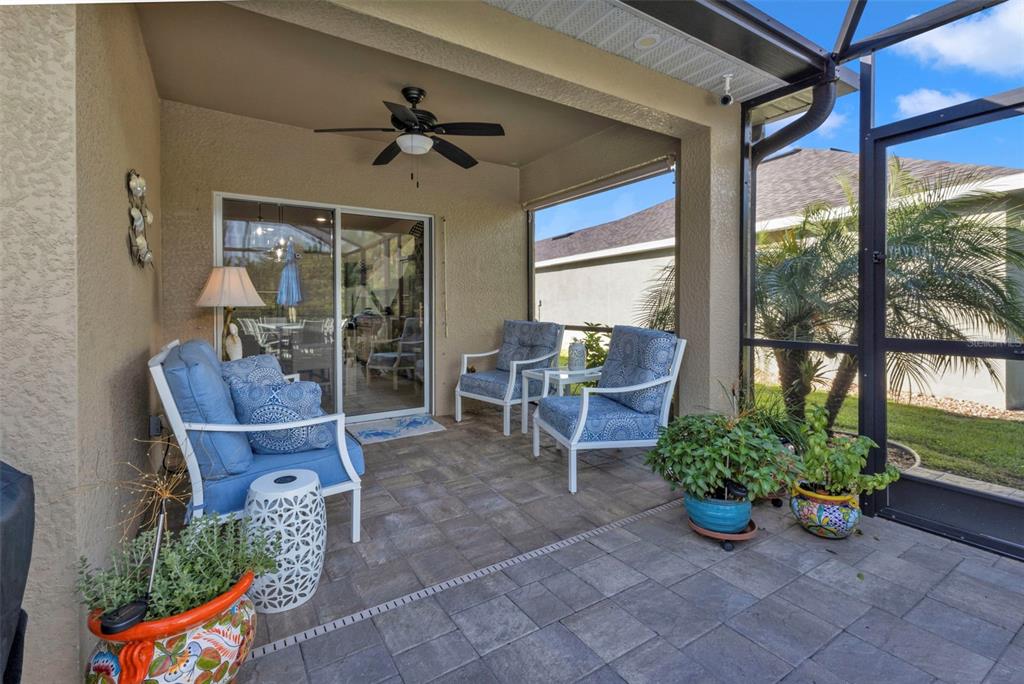 A covered patio features paver flooring, outdoor furniture, and a screened-in enclosure — 7676 MIKASA DRIVE, PUNTA GORDA, FL