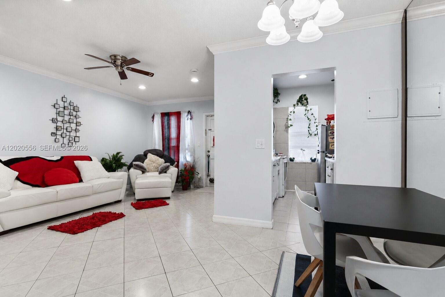 A living room and dining area feature white tile floors, a ceiling fan, and furniture — 2219 Polk St # 5A, Hollywood FL 33020, HOLLYWOOD, FL