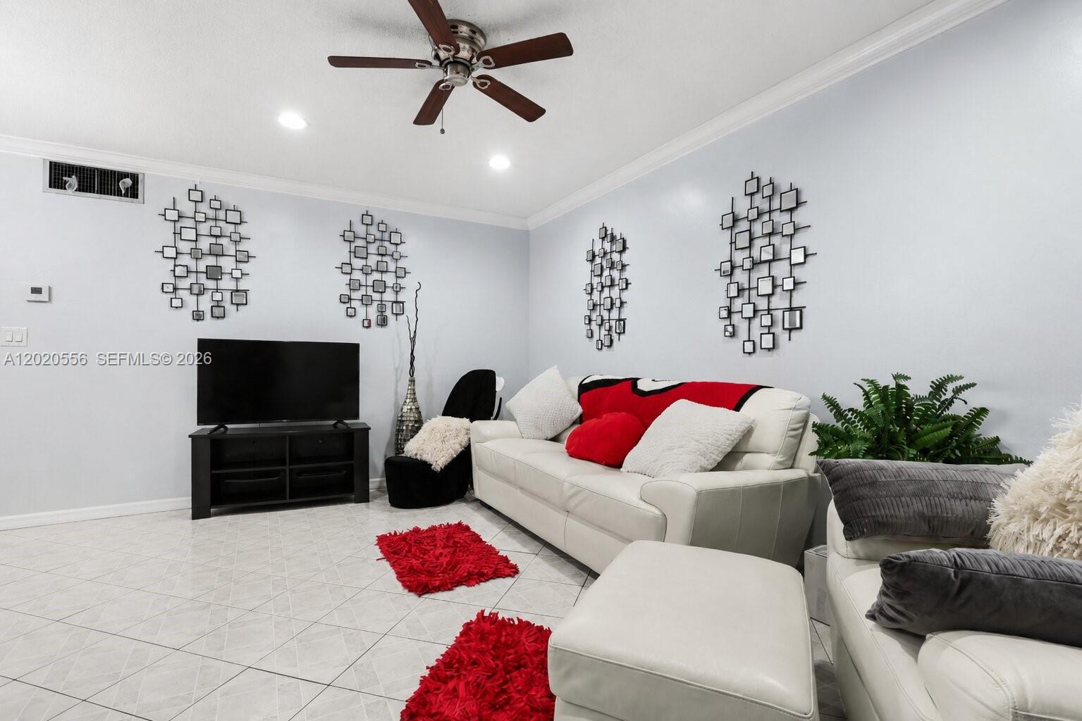 A living room features white tile floors, a white sofa, and black wall art — 2219 Polk St # 5A, Hollywood FL 33020, HOLLYWOOD, FL