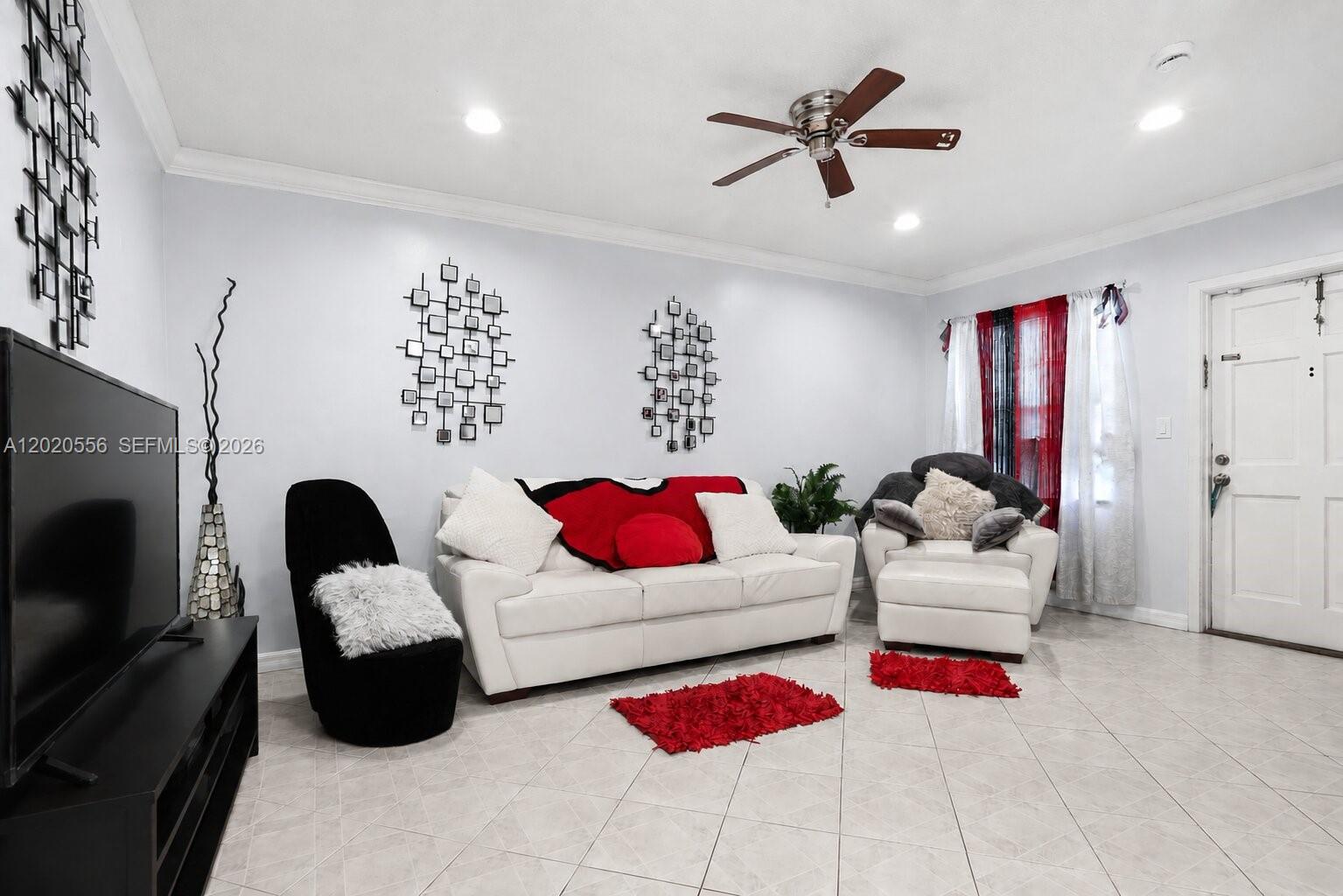 A living room features white tile floors, a white sofa, and black accent furniture — 2219 Polk St # 5A, Hollywood FL 33020, HOLLYWOOD, FL
