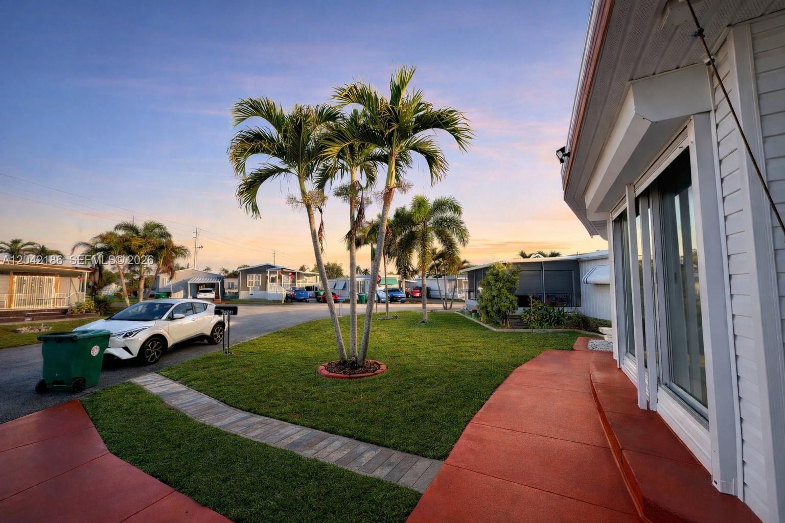 A white car is parked on a driveway next to a lawn with palm trees — 2260 SW 85th Way, Davie FL 33324, DAVIE, FL