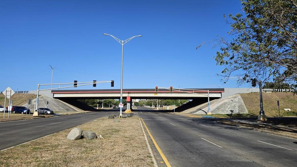 A concrete overpass spans a multi-lane road under a clear blue sky — PR163 int. LAS AMERICAS AVE., PONCE, PR
