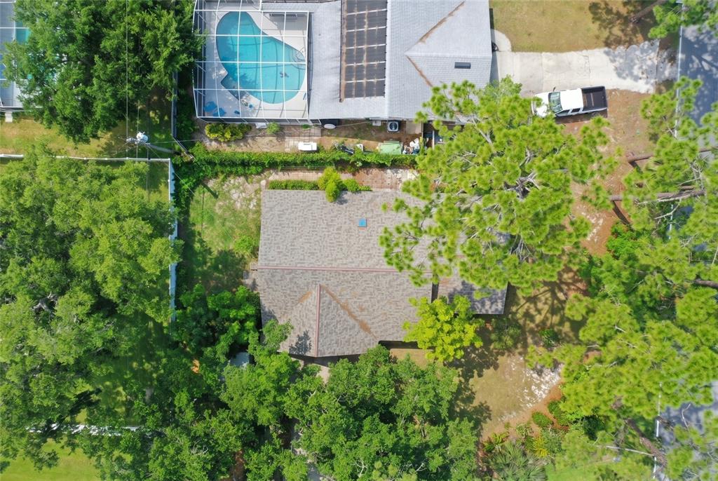 An aerial view shows a house with a shingled roof surrounded by trees and landscaping — 3048 WILLOW OAK DRIVE, EDGEWATER, FL
