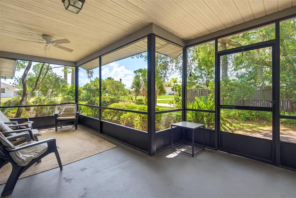 A screened-in porch with a ceiling fan, concrete floor, and views of a backyard — 3048 WILLOW OAK DRIVE, EDGEWATER, FL