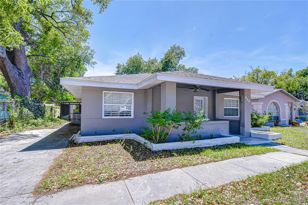 A gray single-story house features a covered front porch and a concrete driveway — 909 HART STREET, CLEARWATER, FL