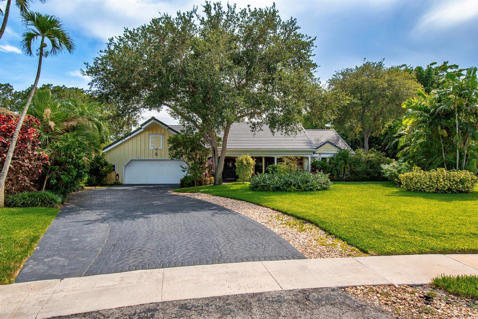 A single-story house with a yellow exterior, a paved driveway, and a large front tree — 6962 S Grande Drive, Boca Raton FL 33433, BOCA RATON, FL
