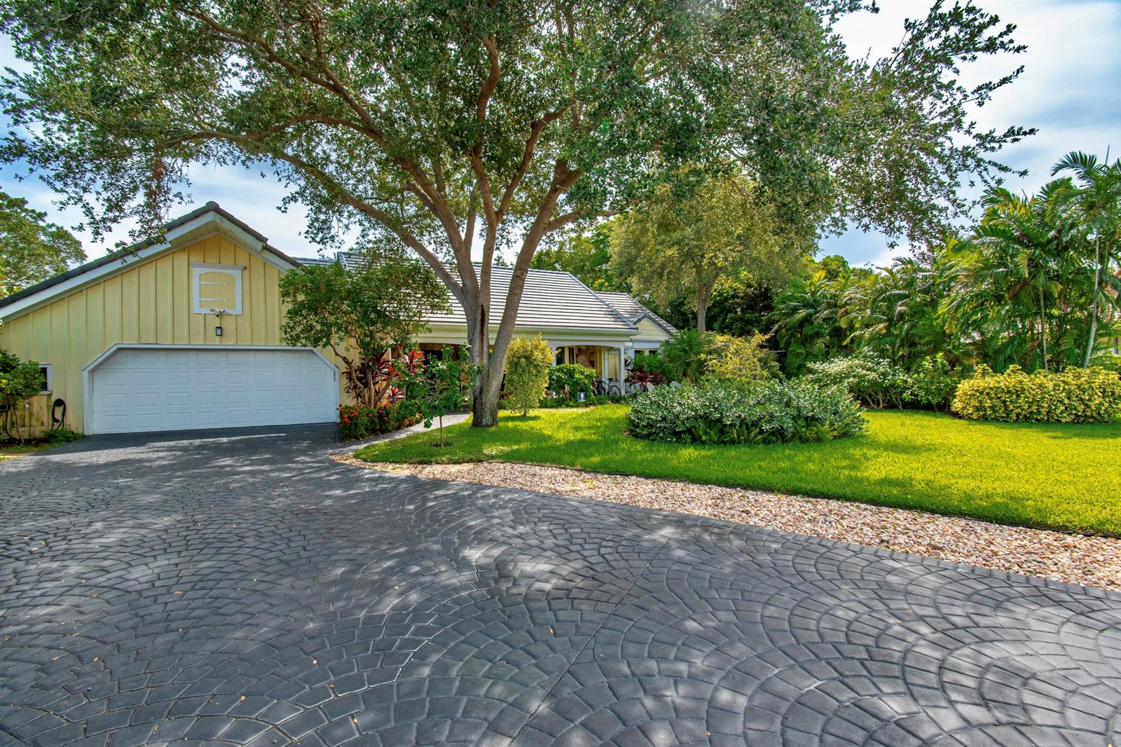 A yellow house with a white garage door and a patterned dark gray driveway — 6962 S Grande Drive, Boca Raton FL 33433, BOCA RATON, FL