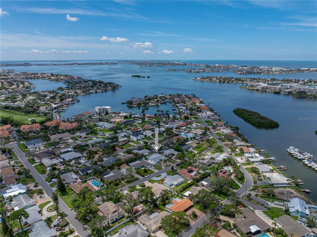 An aerial view shows a residential neighborhood surrounded by water with a marked house — 6709 CARDINAL DRIVE S, ST PETERSBURG, FL
