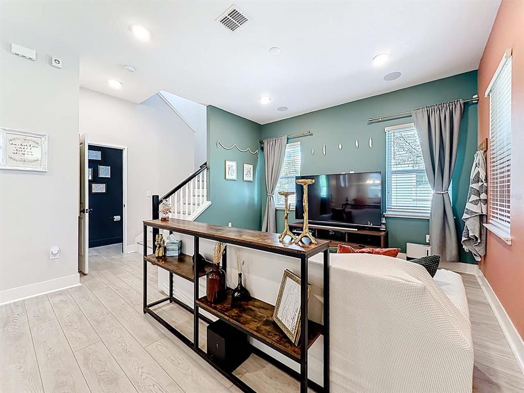 A living room features a teal accent wall, a sofa, and a console table — 13249 CORMACK LANE, ORLANDO, FL