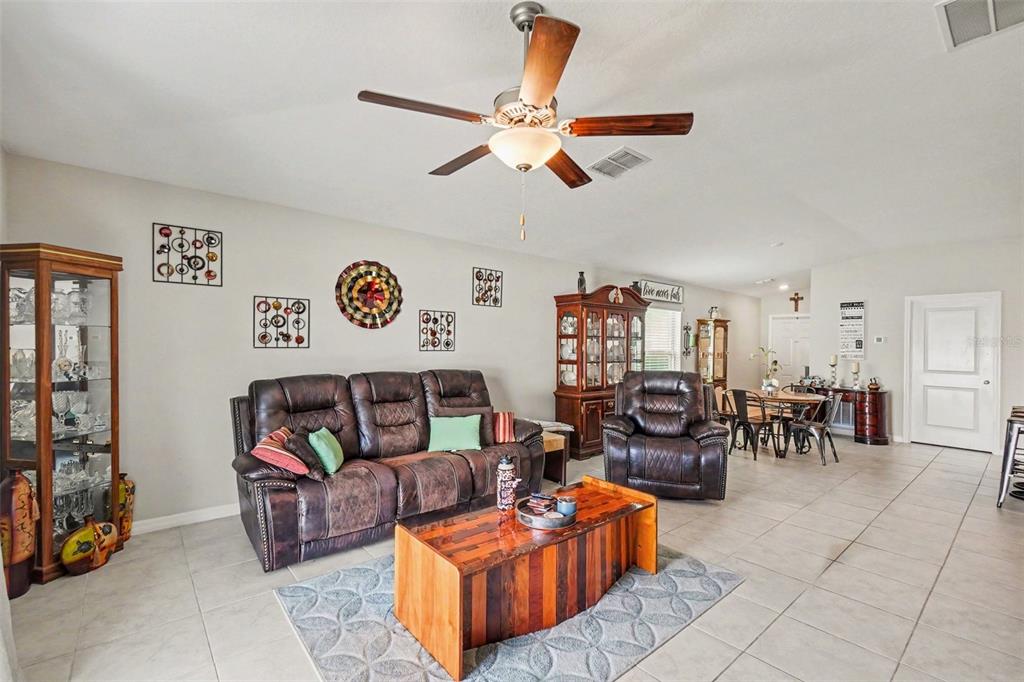 A living room features a leather sofa, a wooden coffee table, and a ceiling fan — 14907 IMPERIAL PURPLE LANE, WIMAUMA, FL