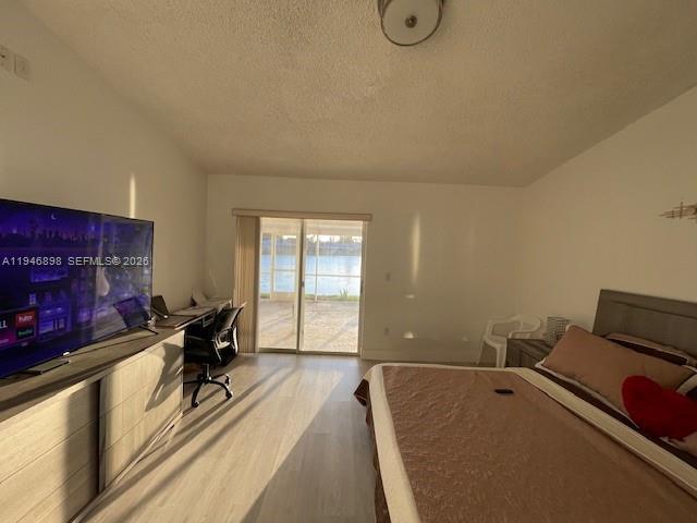 A bedroom with a bed, a television on a dresser, and sliding glass doors — 600 SE 25th Ln, Homestead FL 33033, HOMESTEAD, FL