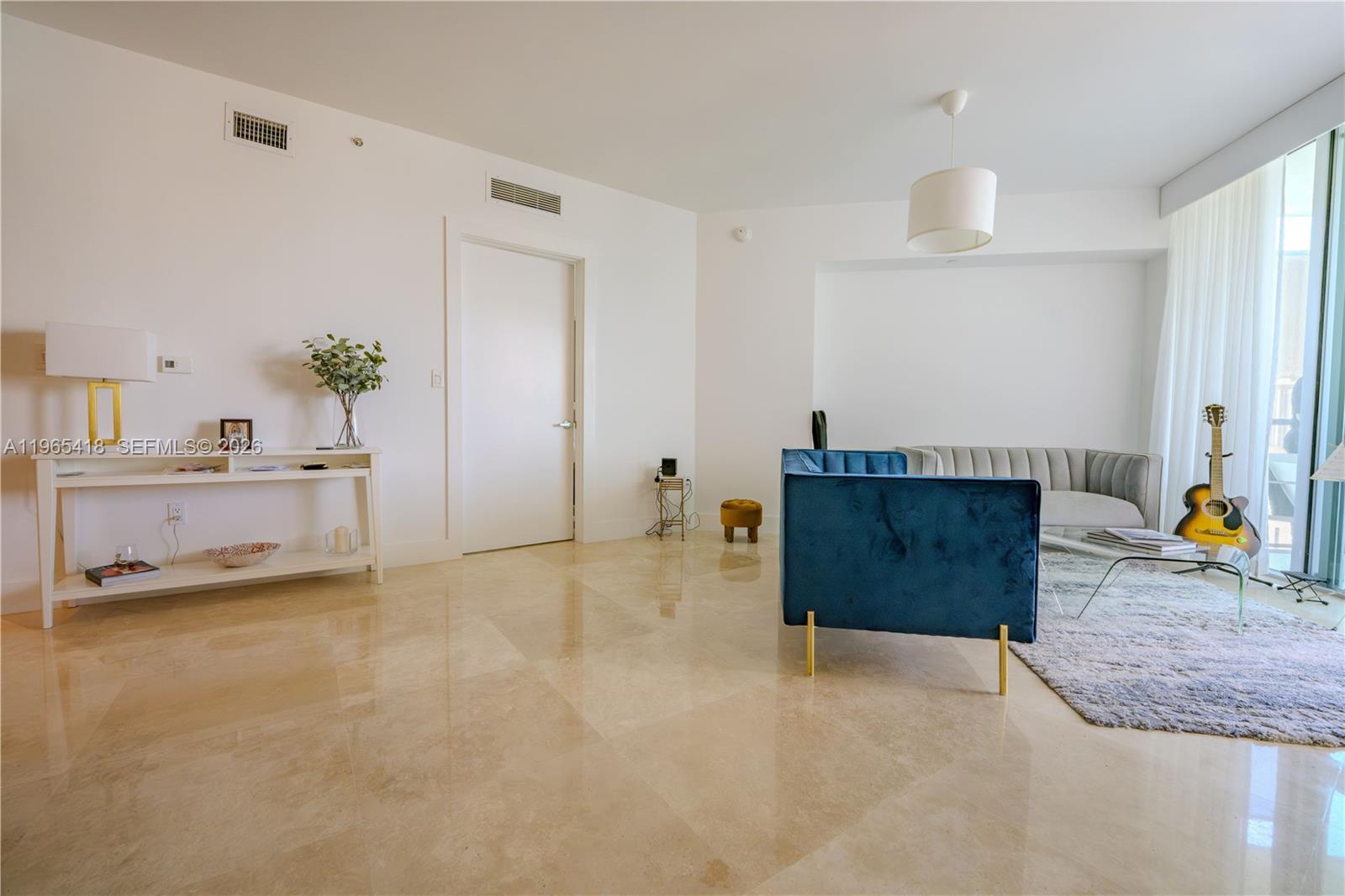 A modern living room features a blue velvet sofa, a grey sofa, and marble flooring — 350 S MIAMI AVE # 3203, Miami FL 33130, MIAMI, FL
