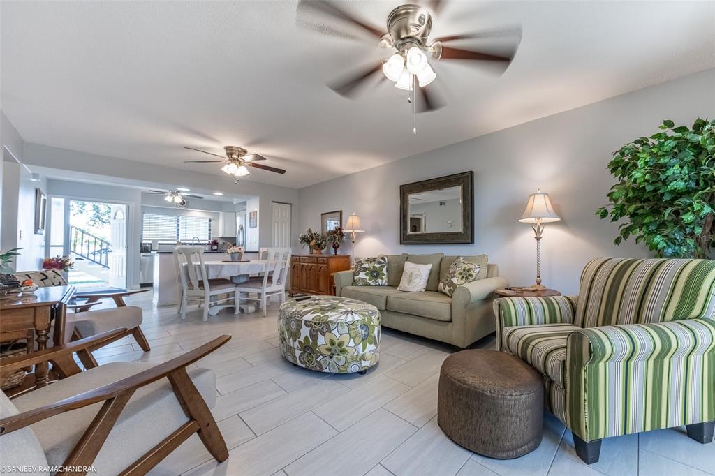 A living room with light tile floors, a ceiling fan, and a striped armchair — 1416 SAN CRISTOBAL AVENUE UNIT 3 (C), PUNTA GORDA, FL