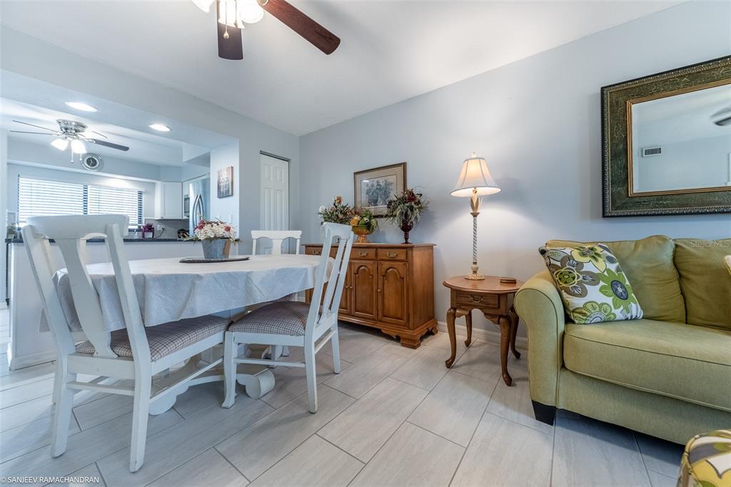 A dining area with a white table and chairs sits beside a green sofa — 1416 SAN CRISTOBAL AVENUE UNIT 3 (C), PUNTA GORDA, FL