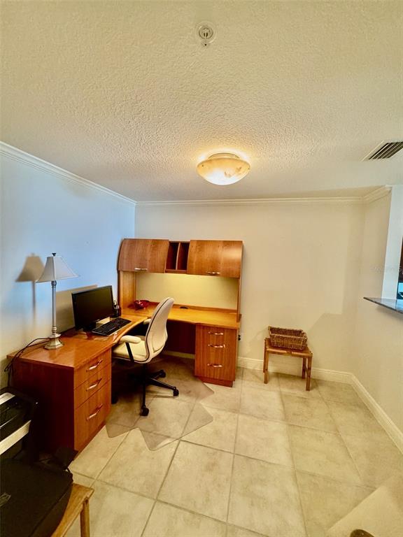 A home office features a wooden desk with a hutch, a chair, and tile flooring — 800 N TAMIAMI TRAIL UNIT 708, SARASOTA, FL