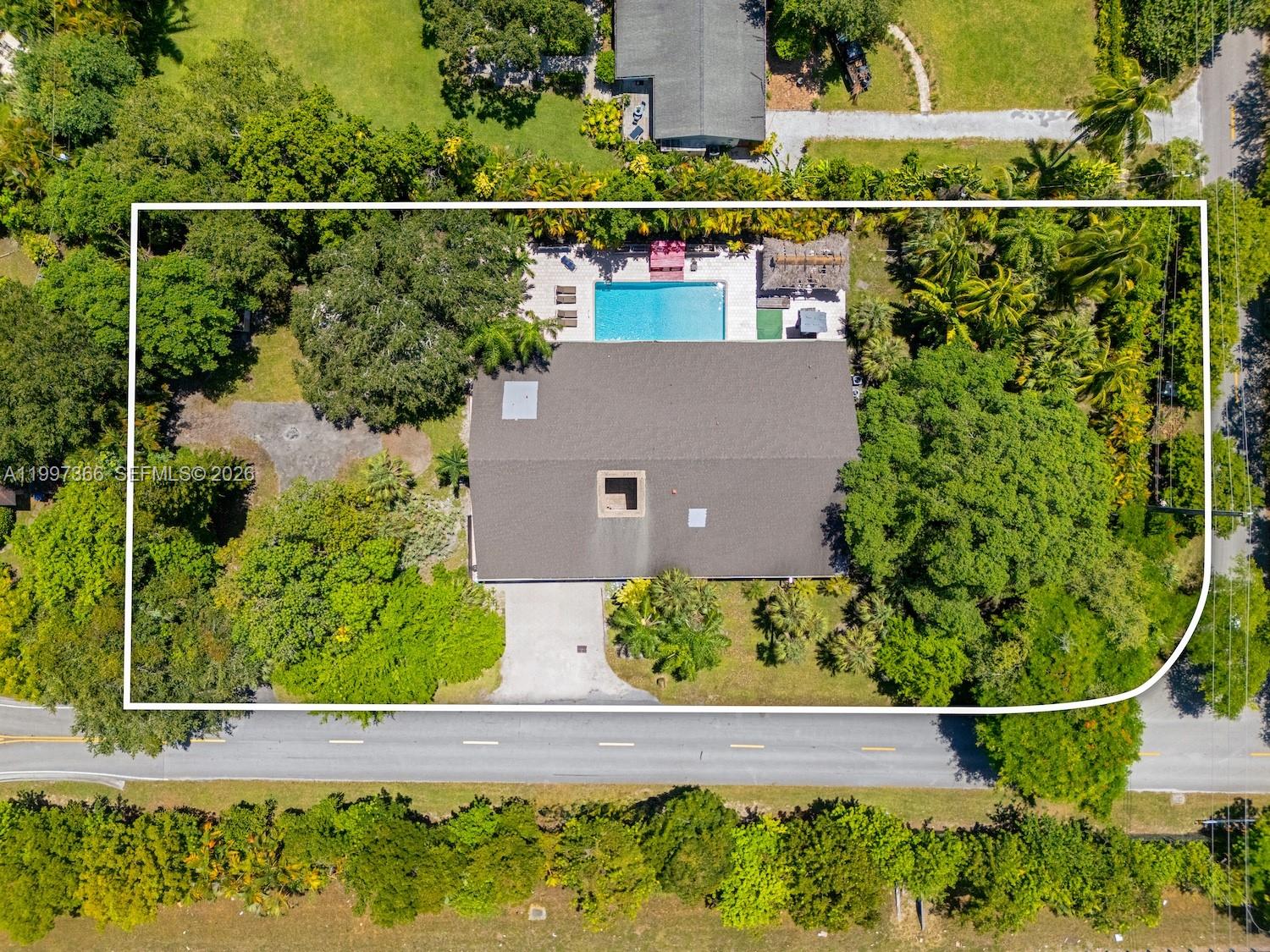 An aerial view shows a house with a pool, patio, and driveway surrounded by trees — 7990 SW 76th Ave, Miami FL 33143, MIAMI, FL
