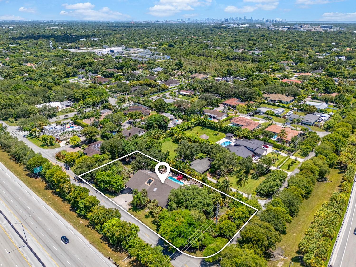 An aerial view shows a single-story house with a pool on a large, wooded lot — 7990 SW 76th Ave, Miami FL 33143, MIAMI, FL