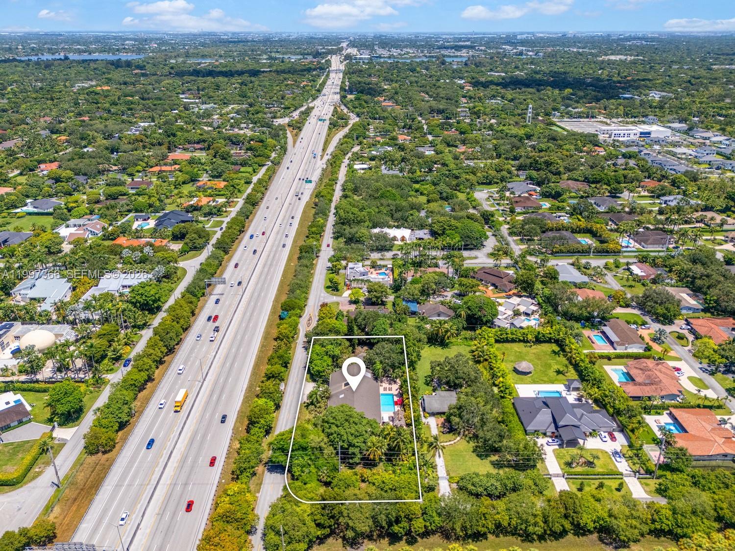 An aerial view shows a residential property with a pool next to a multi-lane highway — 7990 SW 76th Ave, Miami FL 33143, MIAMI, FL