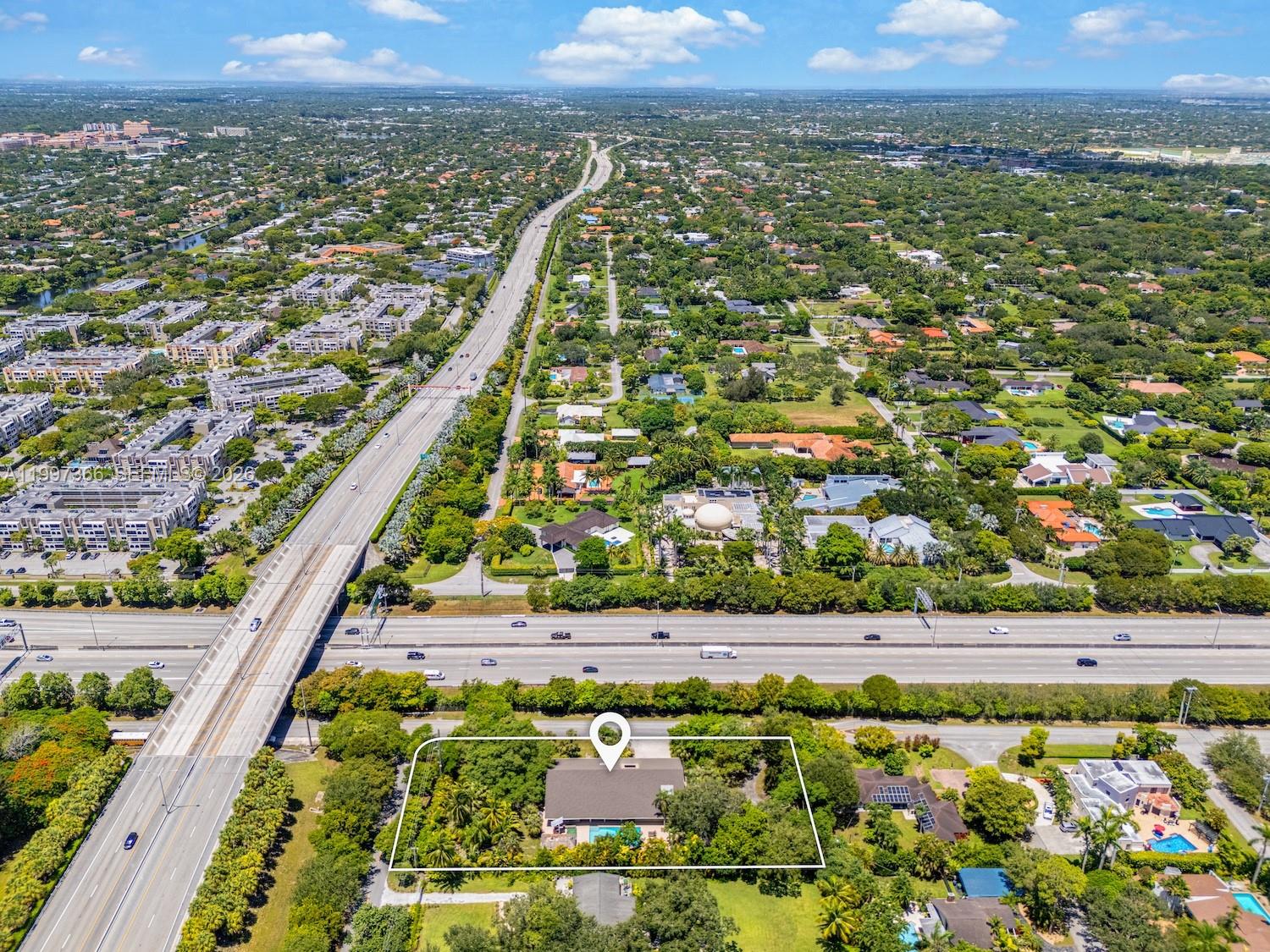 An aerial view shows a single-story house with a pool located next to a highway — 7990 SW 76th Ave, Miami FL 33143, MIAMI, FL