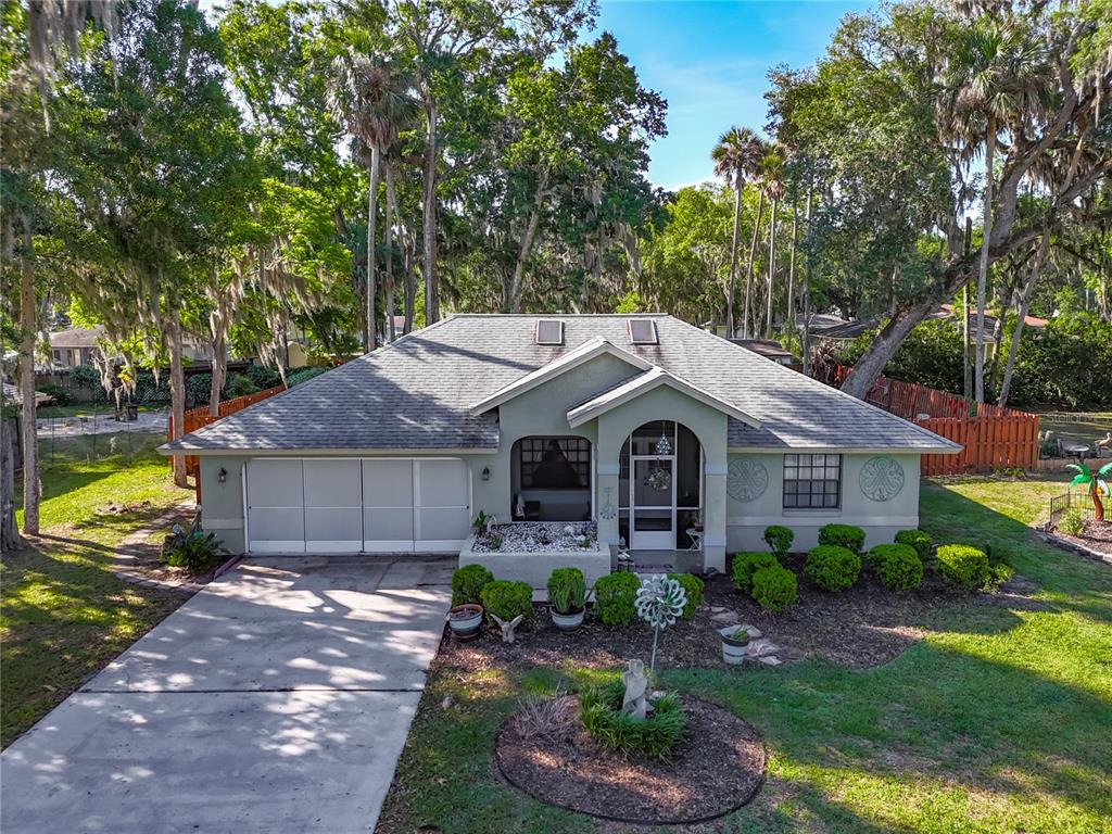 A single-story house with a two-car garage, arched entryway, and a landscaped front yard — 27 BLACK HAWK PLACE, PALM COAST, FL