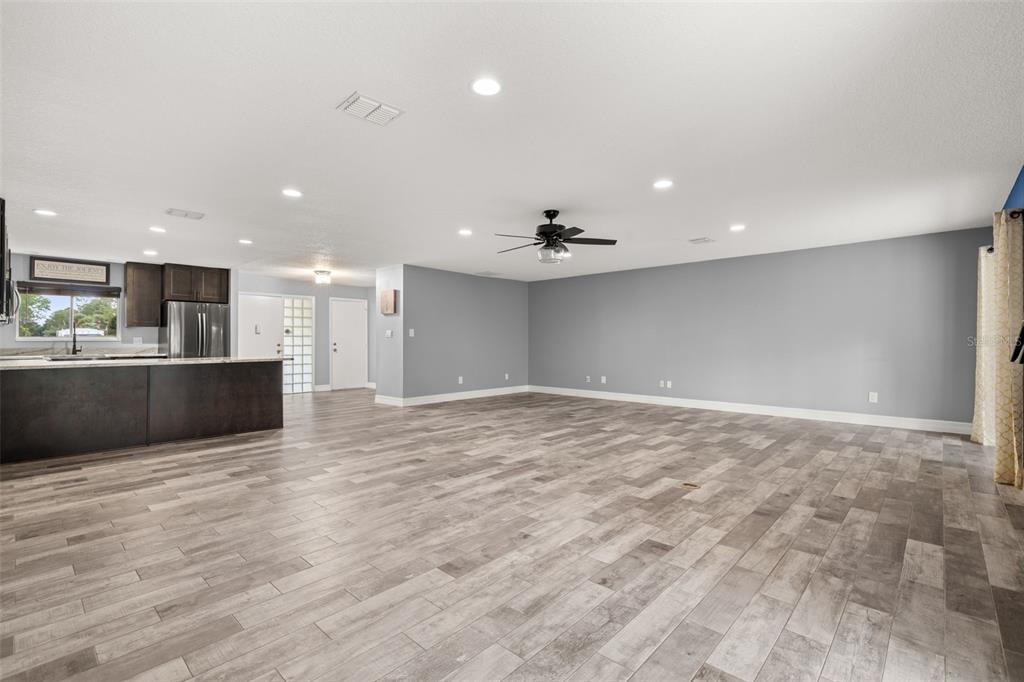 A single-story house with a two-car garage and a concrete driveway under a blue sky — 10702 WILLIAM TELL DRIVE, ORLANDO, FL