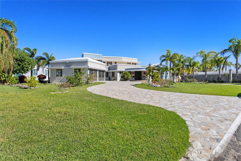 A large, modern, light-colored house with a stone driveway and palm trees in the yard — 10 URB MIRADOR DEL CIELO, ISABELA, PR