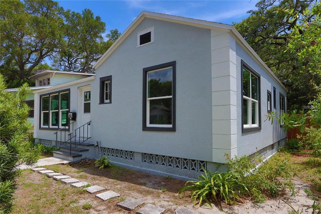 A light blue house with dark-trimmed windows and a decorative concrete block foundation — 1532 13TH STREET S, ST PETERSBURG, FL