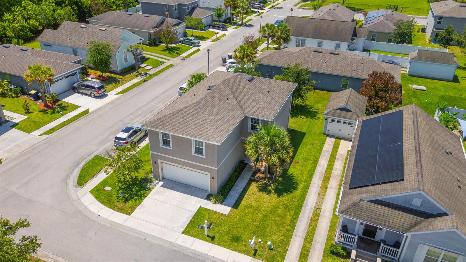 An aerial view shows a two-story suburban house with a garage and a detached garage — 3351 Liberty Square Way, Fort Pierce FL 34982, FORT PIERCE, FL