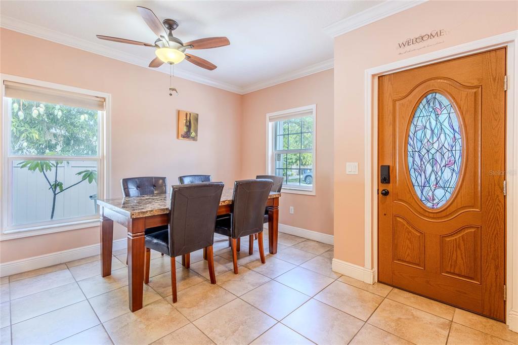 A dining room features a wooden table, dark chairs, tile flooring, and a front door — 2920 EDGEWOOD LANE, SARASOTA, FL