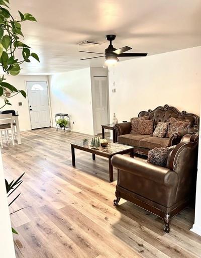 A living room features wood-look flooring, a ceiling fan, and a brown tufted sofa set — 14536 SW 34TH TERRACE ROAD, OCALA, FL