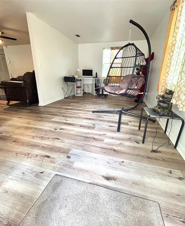 A living area features wood-look flooring, a hanging egg chair, and a desk workspace — 14536 SW 34TH TERRACE ROAD, OCALA, FL
