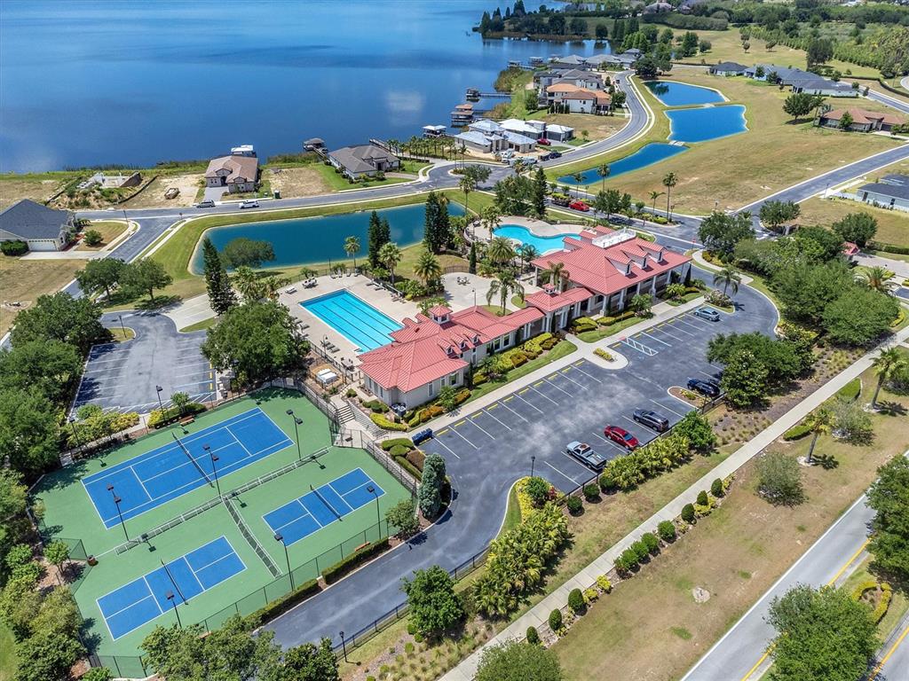An aerial view shows a community clubhouse with a pool, tennis courts, and parking lot — 171 BLAZING STAR AVENUE, LAKE ALFRED, FL