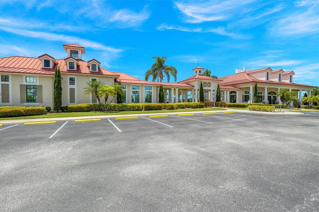 A large, light-colored building with a red metal roof sits behind a paved parking lot — 171 BLAZING STAR AVENUE, LAKE ALFRED, FL