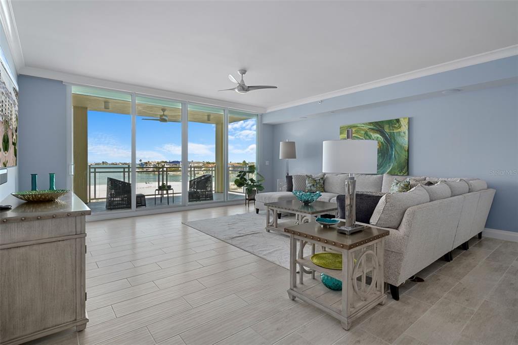 An aerial view shows a multi-story yellow residential building with a pool and waterfront scenery — 650 COLLANY ROAD UNIT 405, TIERRA VERDE, FL