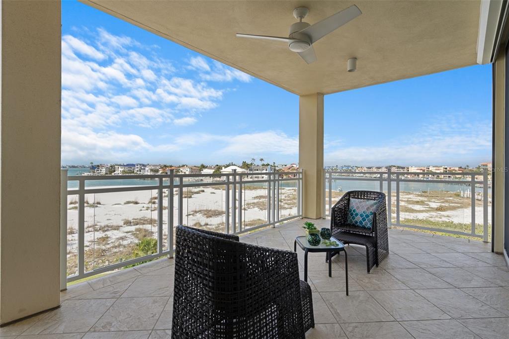 A living room with light tile floors, a large sectional sofa, and a balcony view — 650 COLLANY ROAD UNIT 405, TIERRA VERDE, FL